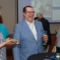 Guests smile while speaking together at a table